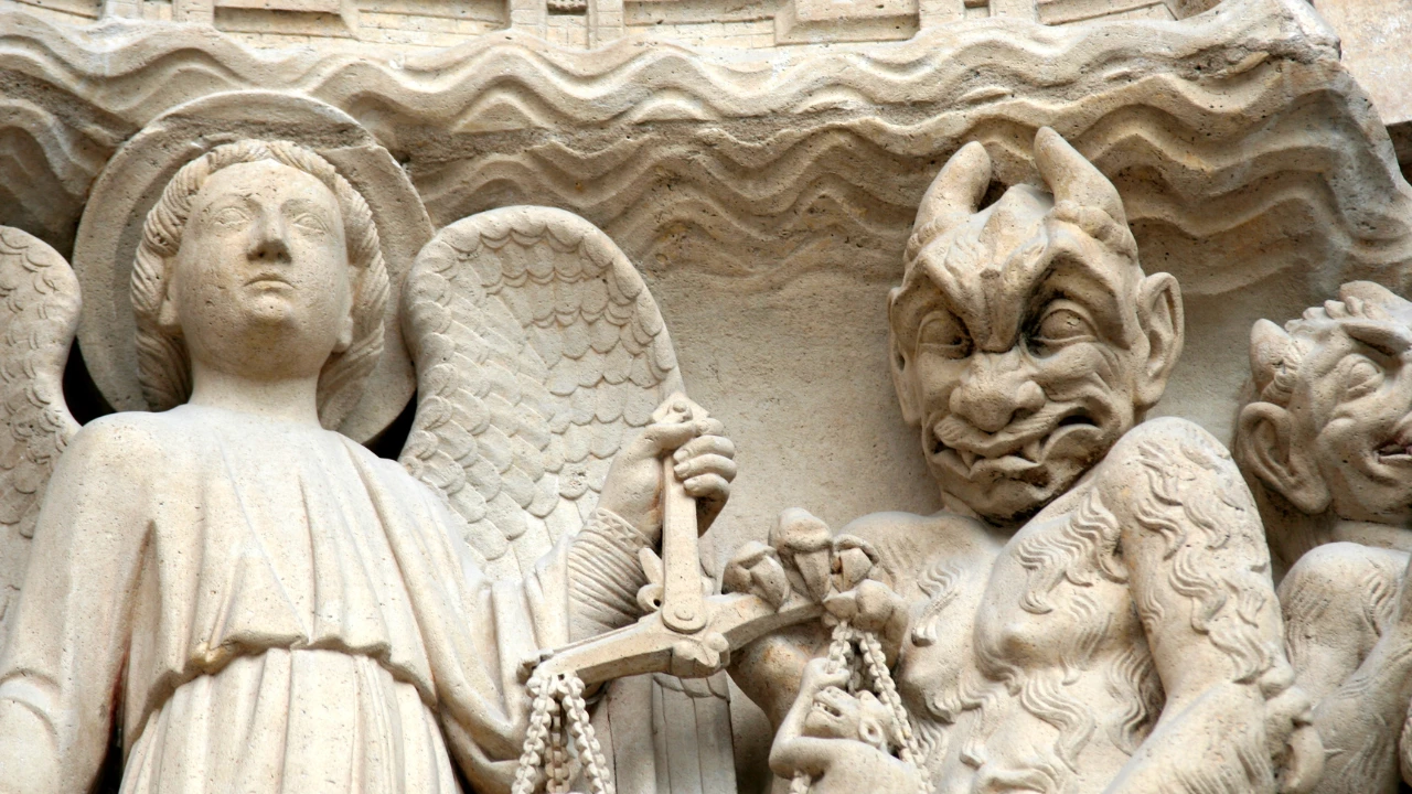 A gargoyle and angel stone statue.