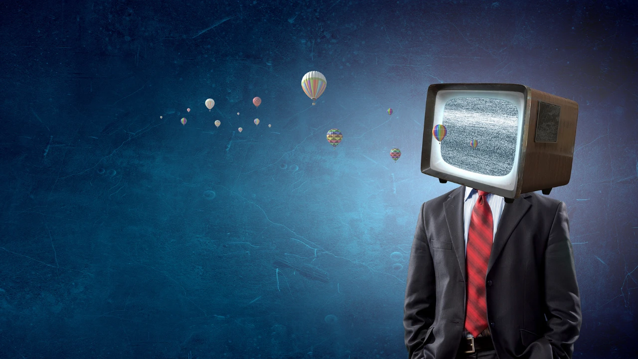 A man wearing a suit with a TV for a head on a blue background.