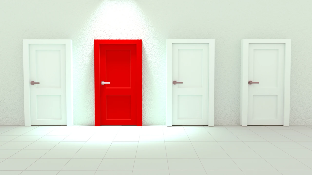 Three white doors and one red door with a spotlight shining on it.