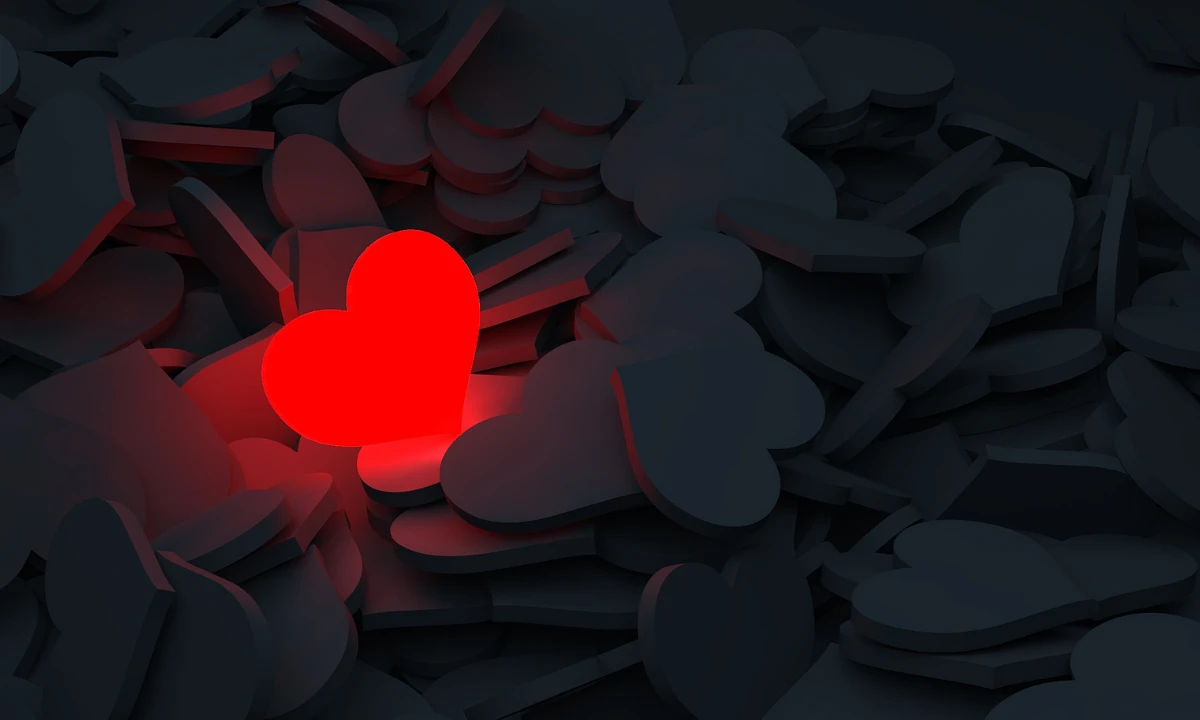 Silhouetted hearts on a dark background with a red glowing heart in the middle.