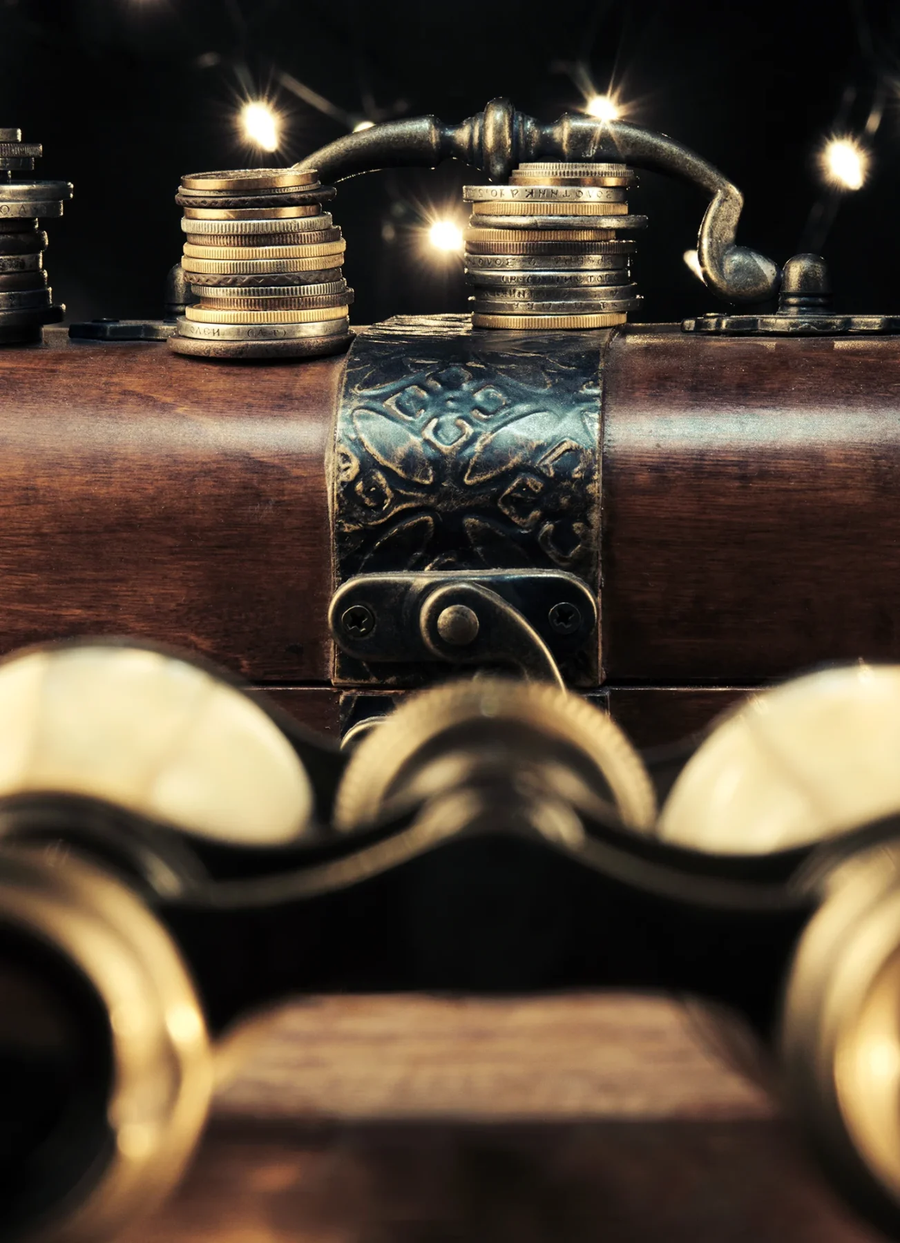 A classic set of gold binoculars sat on mahogany desk with a gun laid behind